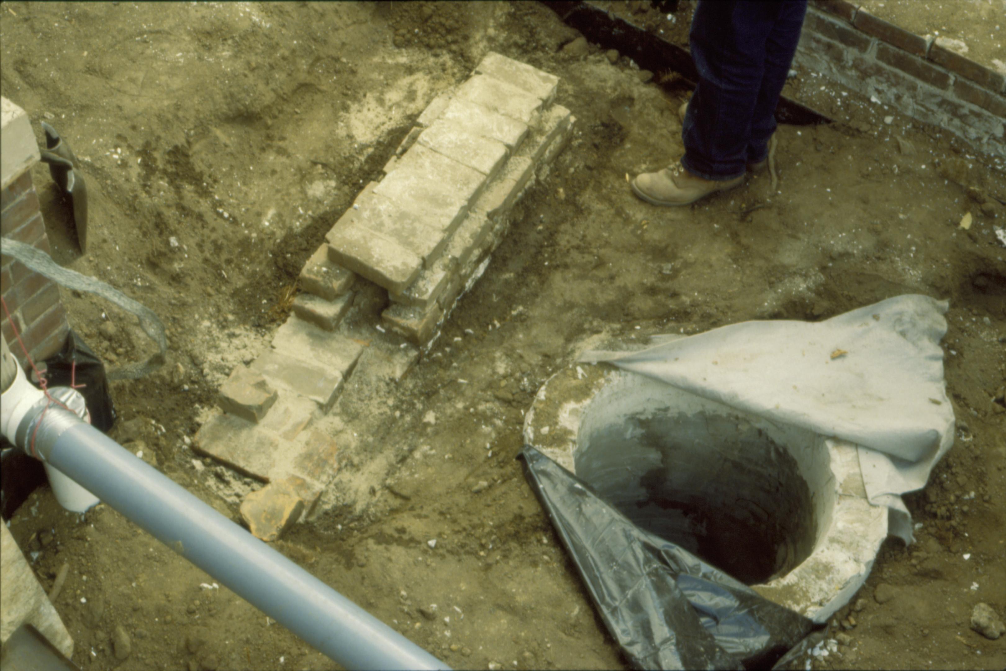 The runoff drain and an older brick structure in the Lincoln Home front yard, southwest corner. The items were uncovered during the 1987-88 Lincoln Home restoration. Photographer facing southeast. The north face of the south-facing retaining wall can be seen at the top right of the photo.
