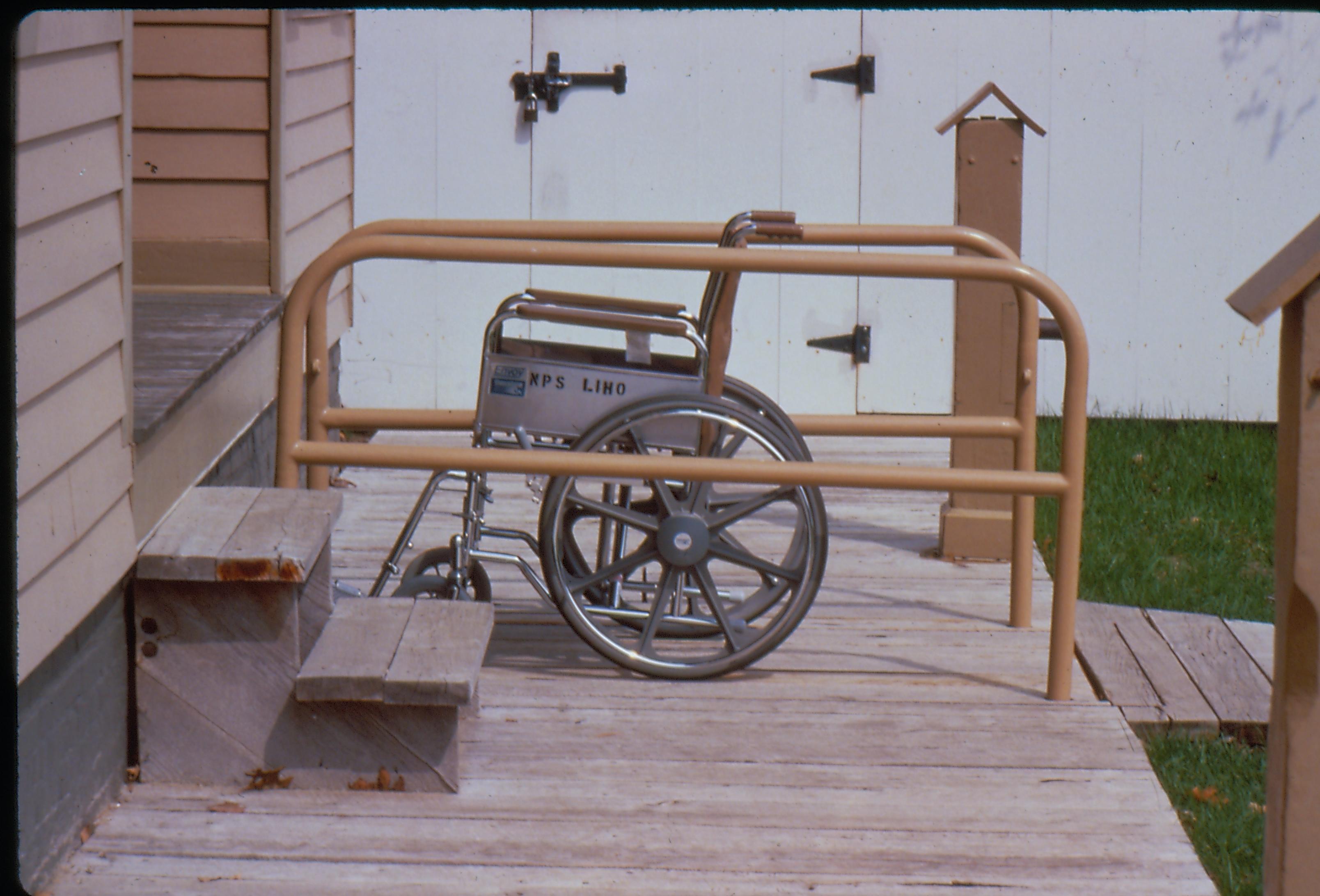 Lincoln Home wheelchair lift, fully retracted, with empty wheelchair. Photographer facing north.