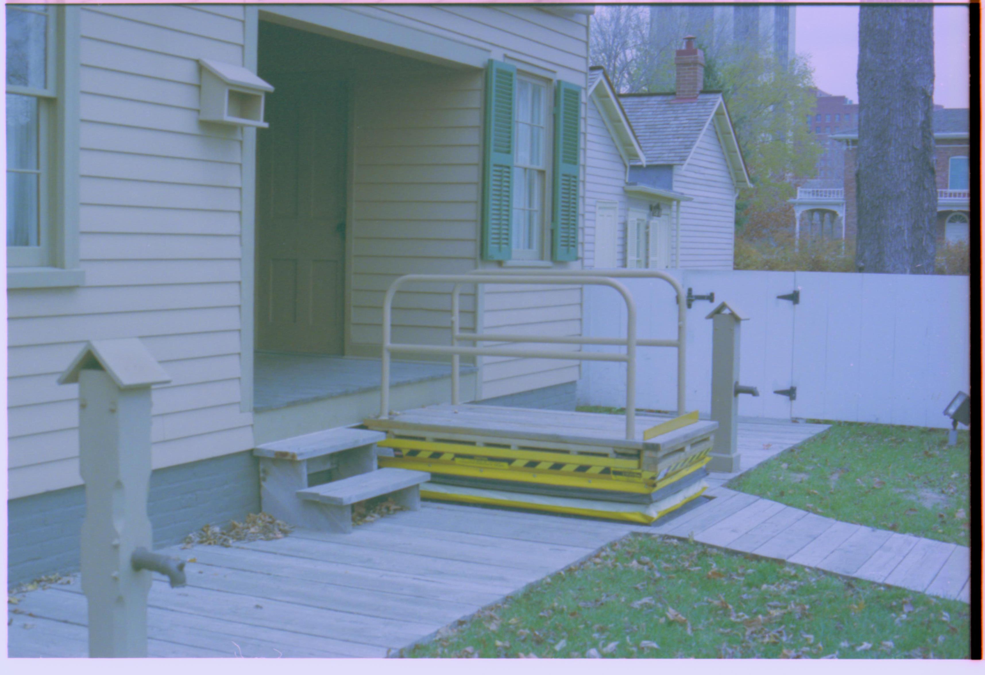 Wheelchair lift of the Lincoln home at three-quarters-height. Photographer facing north west.