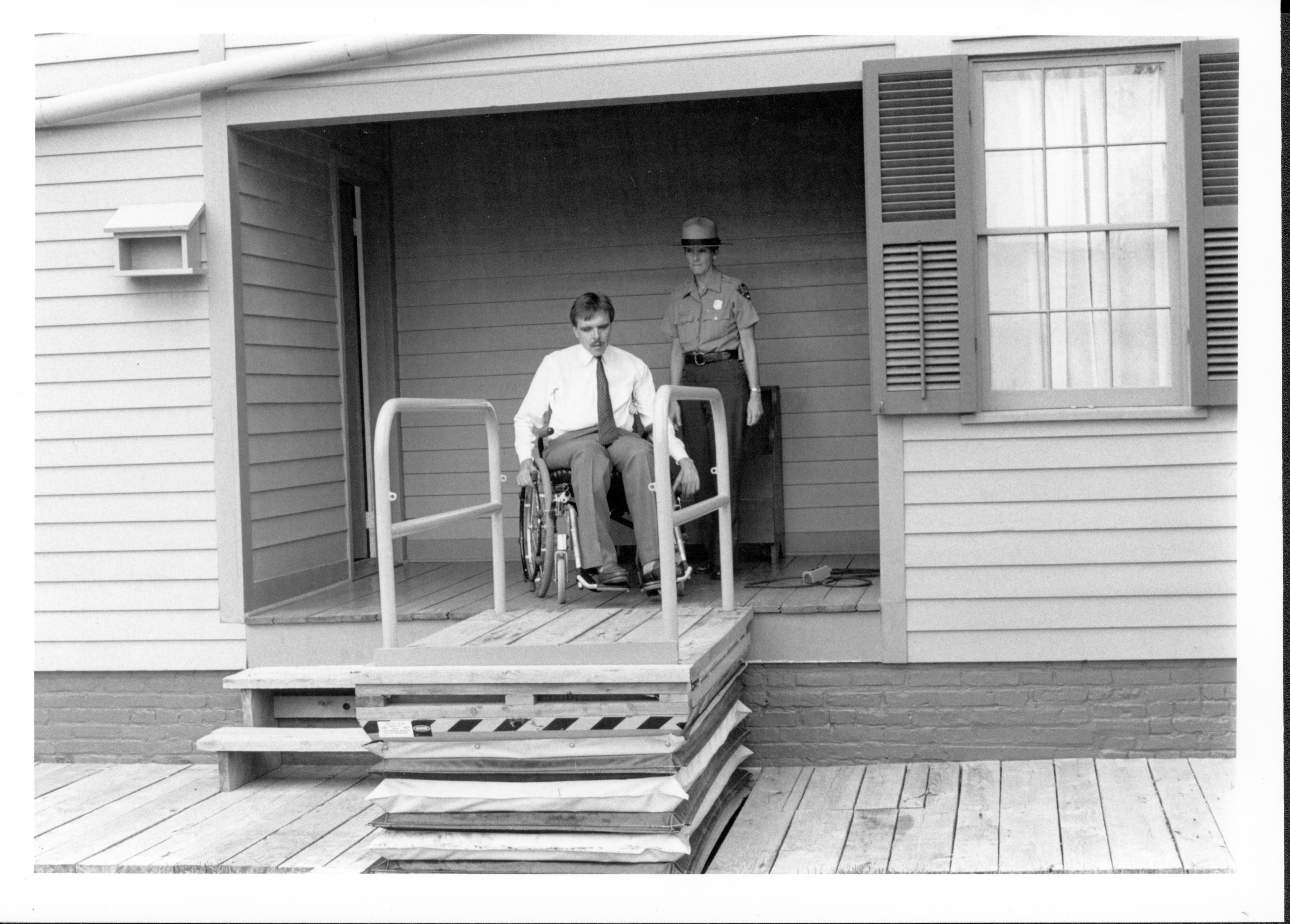 Kathy DeHart, and Richard L. Blakley, Director, Springfield Center for Independent Living, testing the Lincoln Home back yard wheelchair lift.
