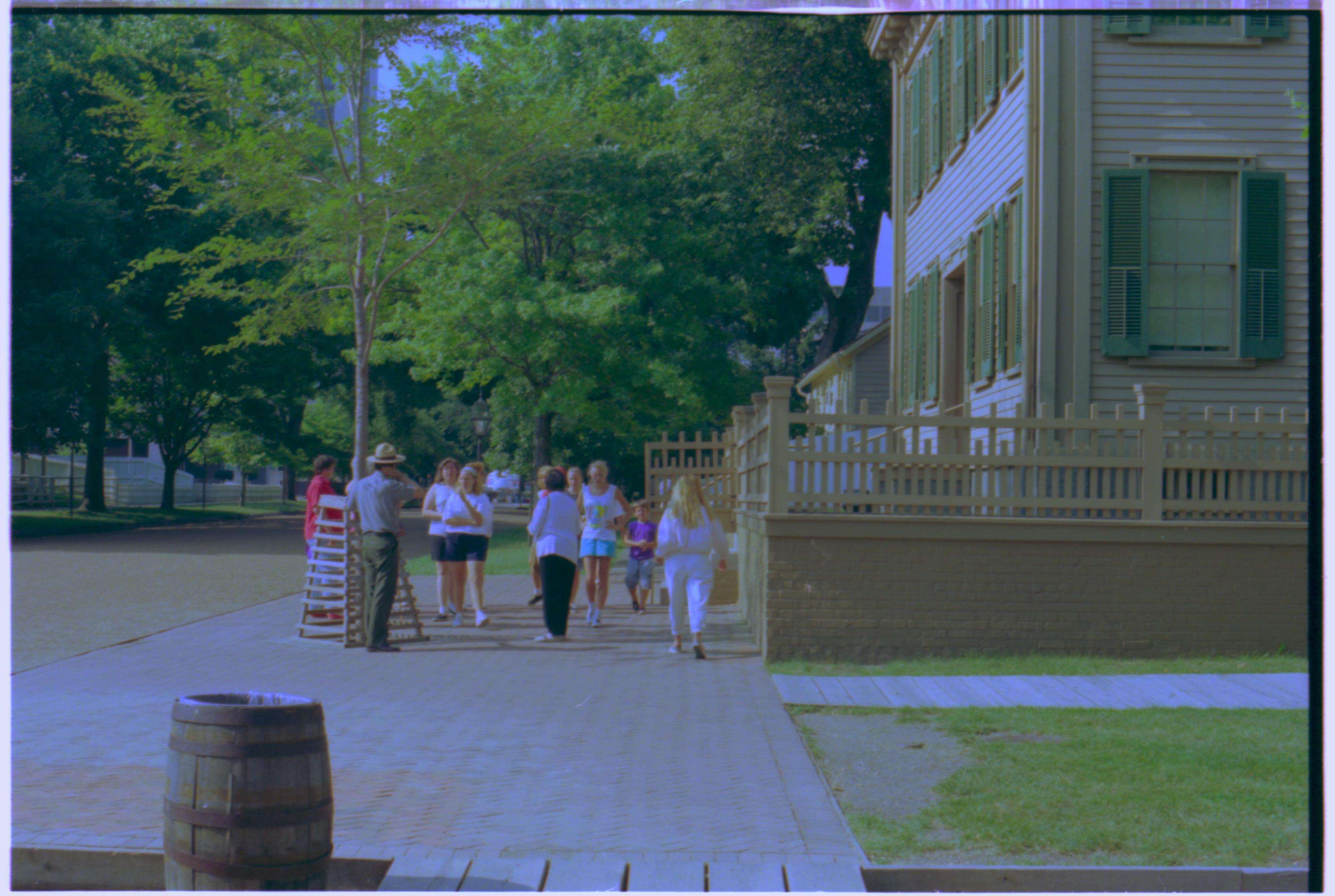 A ranger with a group of visitors on the brick plaza west of the Lincoln Home. Summer. Photographer facing north.