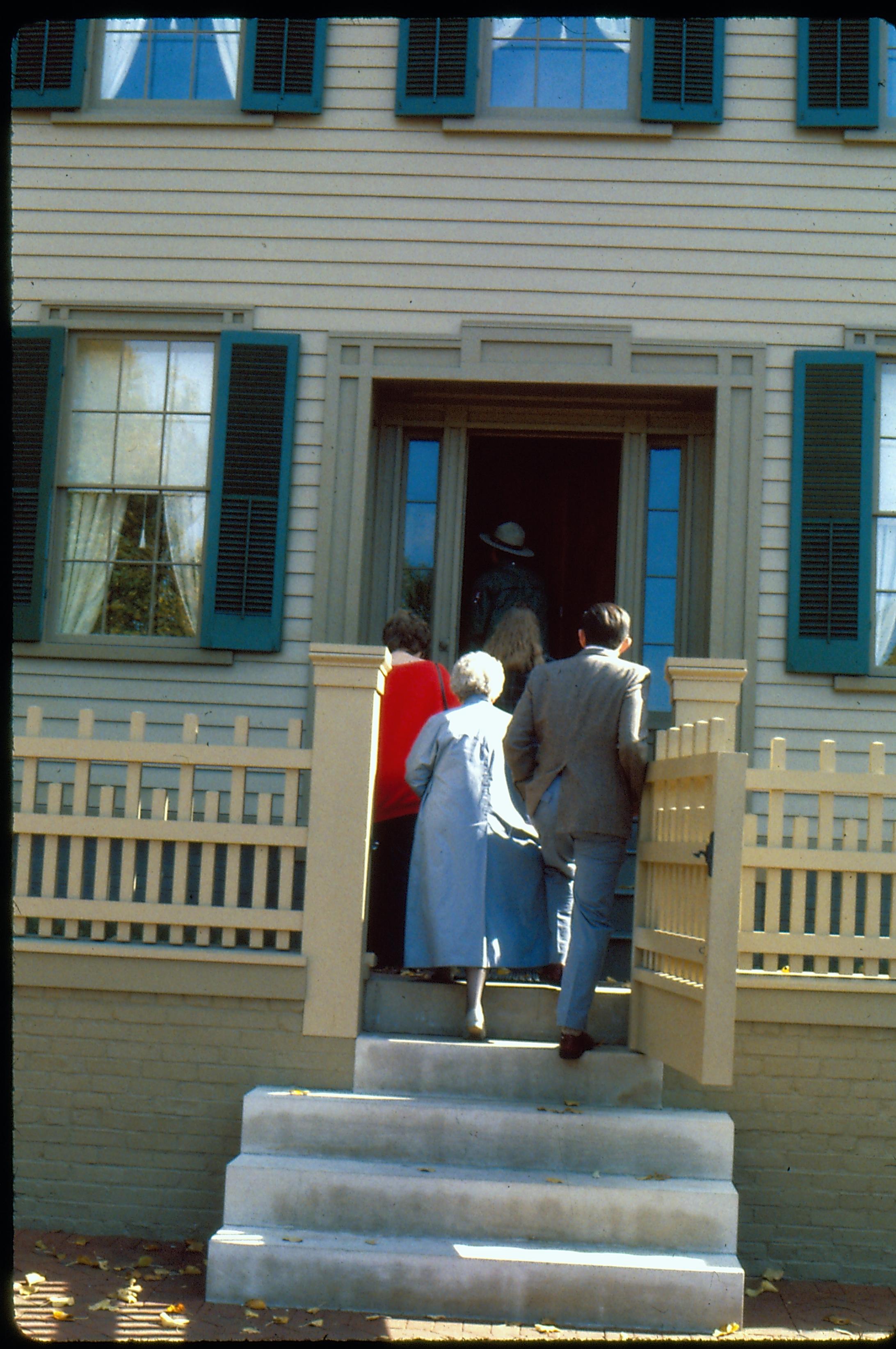 A group of visitors follow a NPS ranger into the Lincoln Home through the west (main) entrance. Photographer facing east.