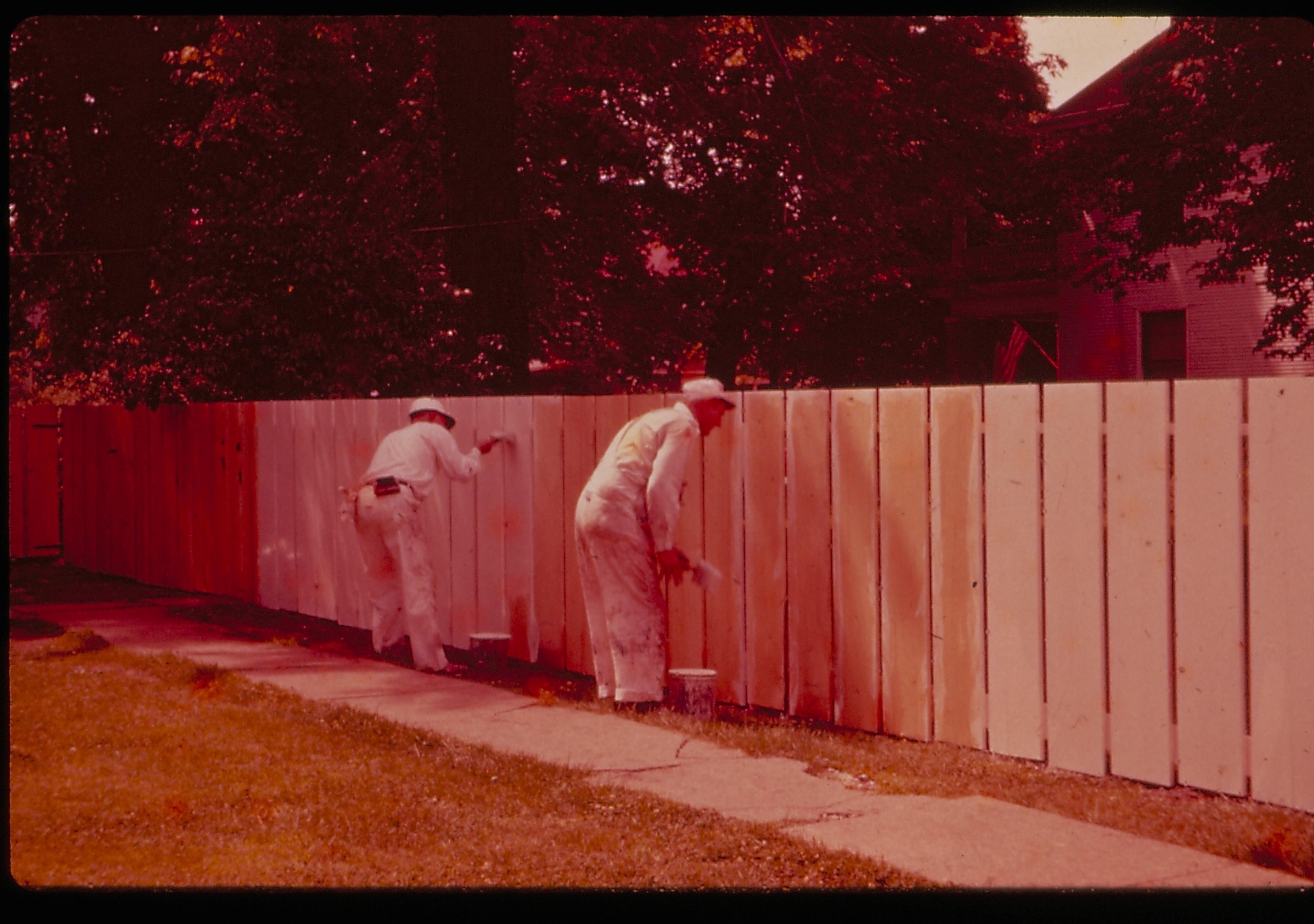 Two painters painting the fence on the north side of the Lincoln Home lot. Photographer facing northwest.