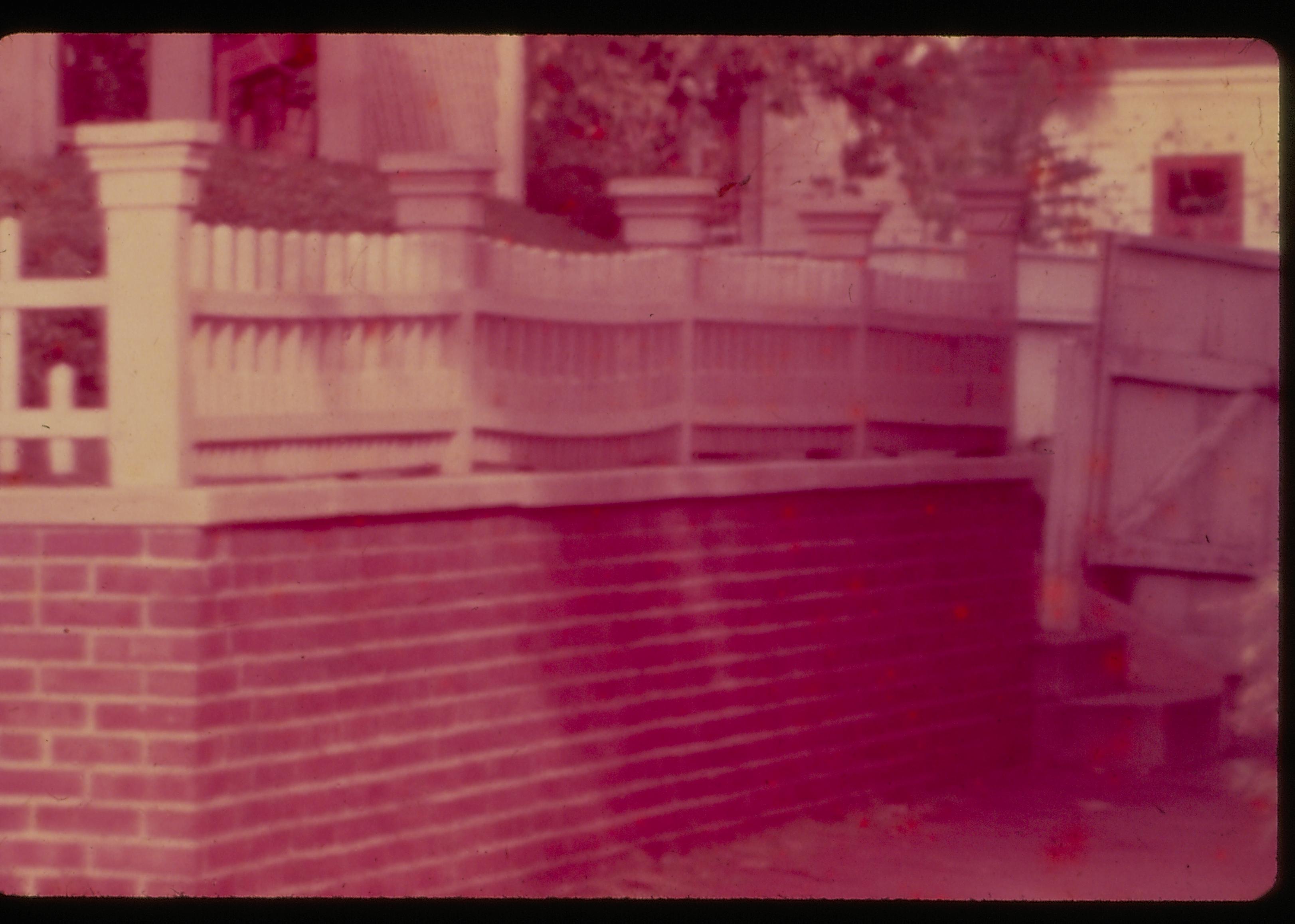 Lincoln Home south retaining wall, gate, and south porch after the 1954 State of Illinois restoration. Carriage house in the background. Photographer facing north east.