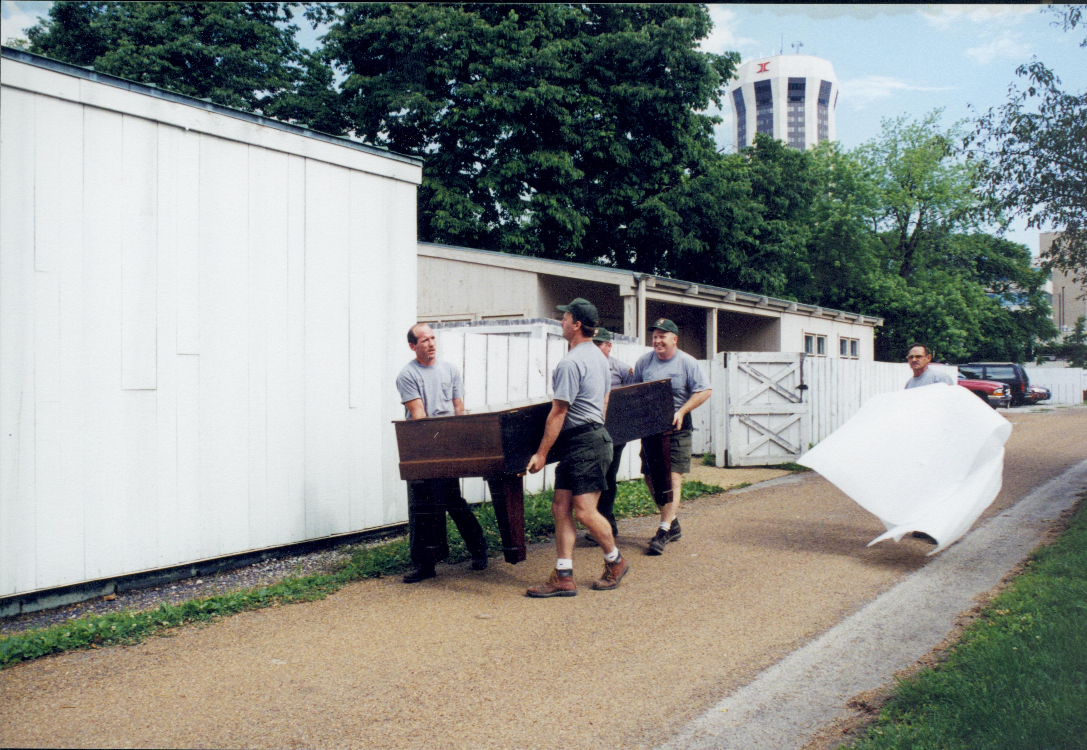 Members of Maintenance moving piano from Carriage House storage area to new location in Arnold Barn Lincoln Home NHS, 1998 CRS Collection Move, East alley, Roll N7, exp 7 sheet 3 of 9 Carriage House, storage room