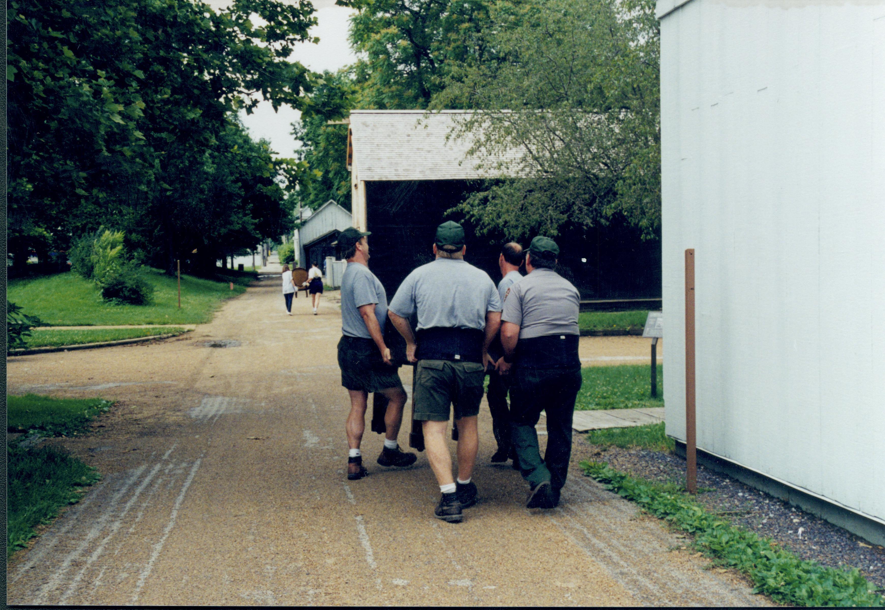 Members of Maintenance moving piano from Carriage House storage area to new location in Arnold Barn Lincoln Home NHS, 1998 CRS Collection Move, East alley, Roll N7, exp 8 sheet 3 of 9 Carriage House, storage room