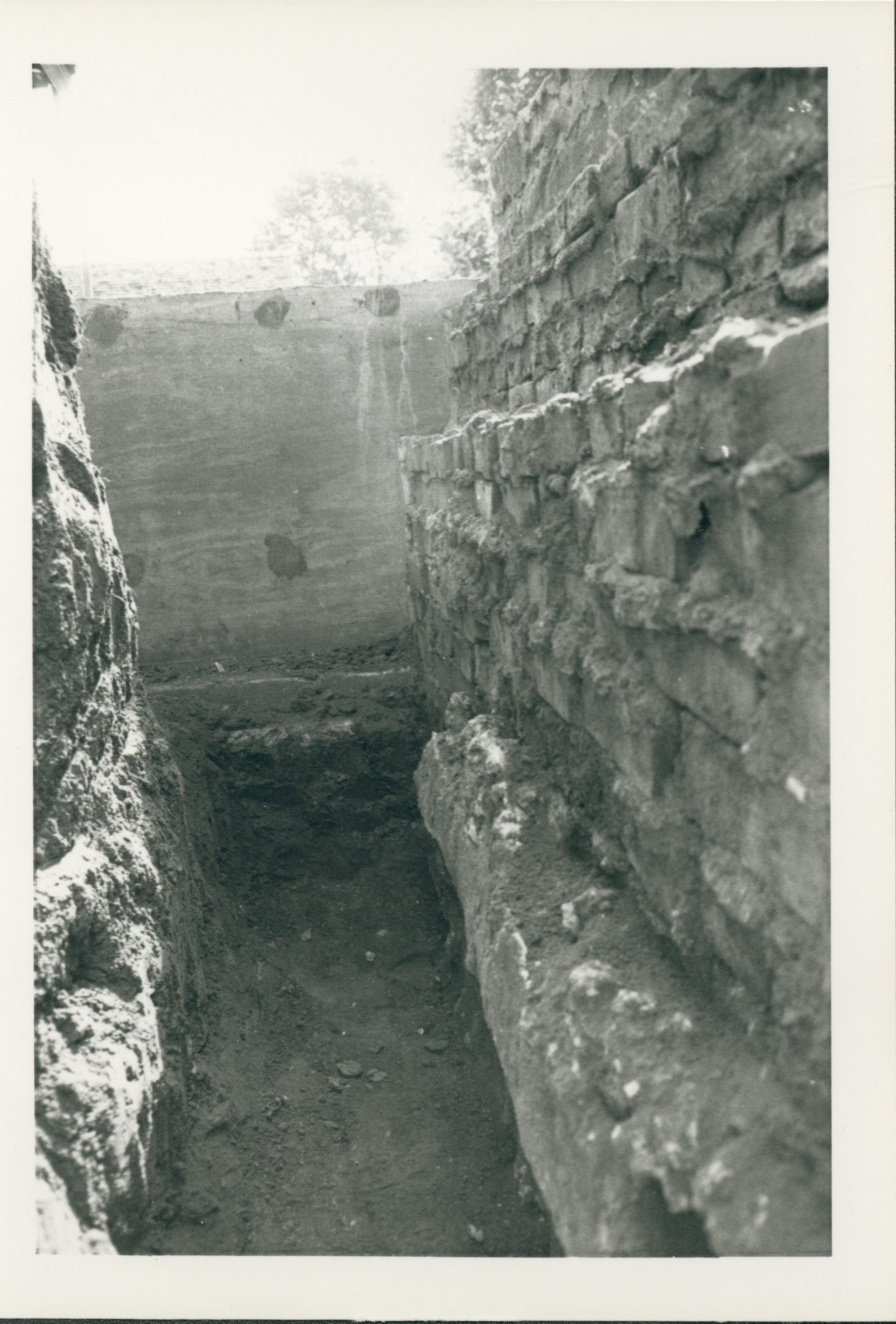 Trench on the south side of the Lincoln Home. A section of retaining wall can be seen on the right of the picture. The plywood at the middle of the photo is a temporary wall for the south gate and steps for the Lincoln Home and lot. Photographer is facing east.