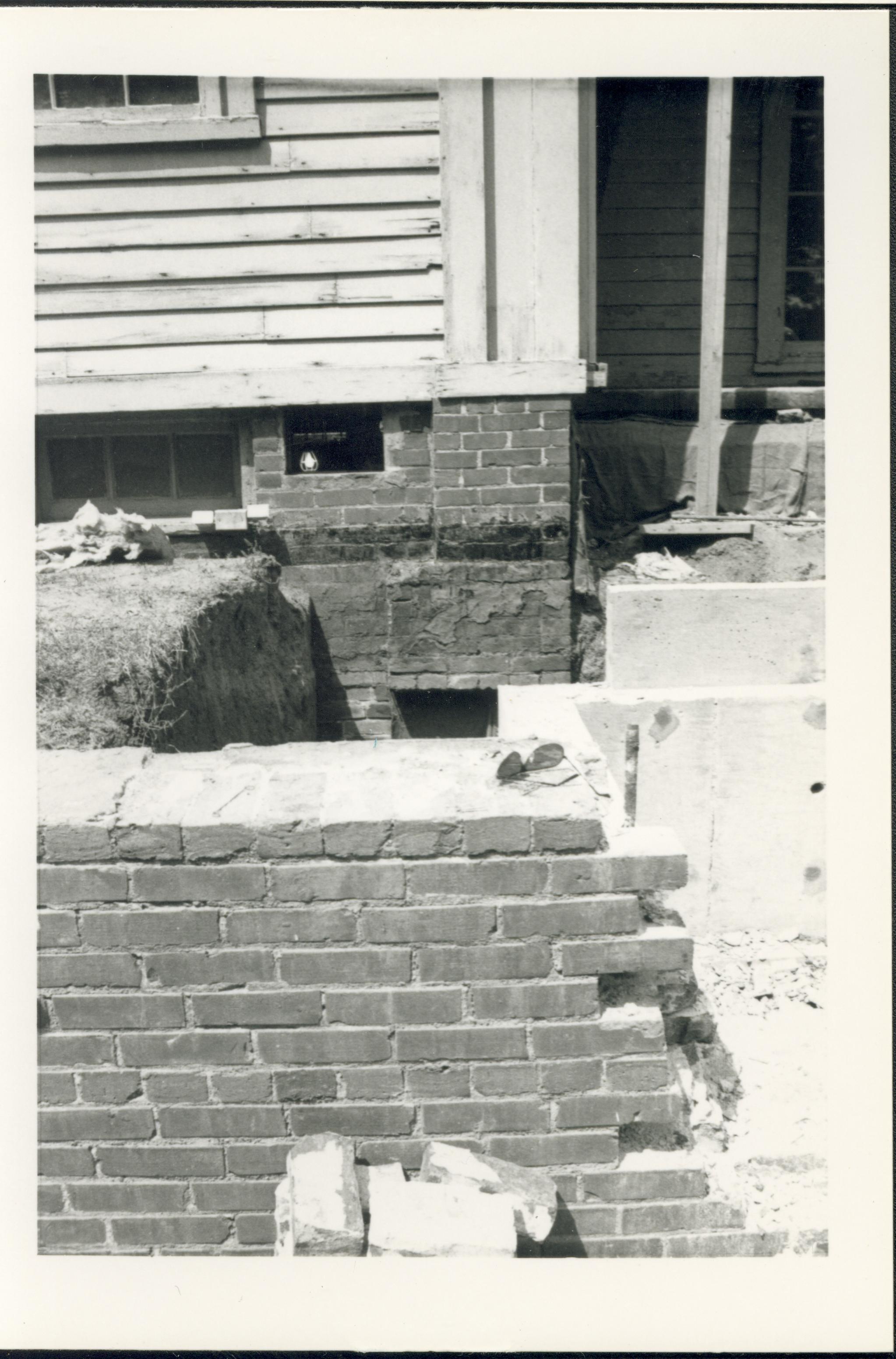 Lincoln Home foundation, south porch, and retaining wall during 1985 archaeology dig. Photographer facing north.