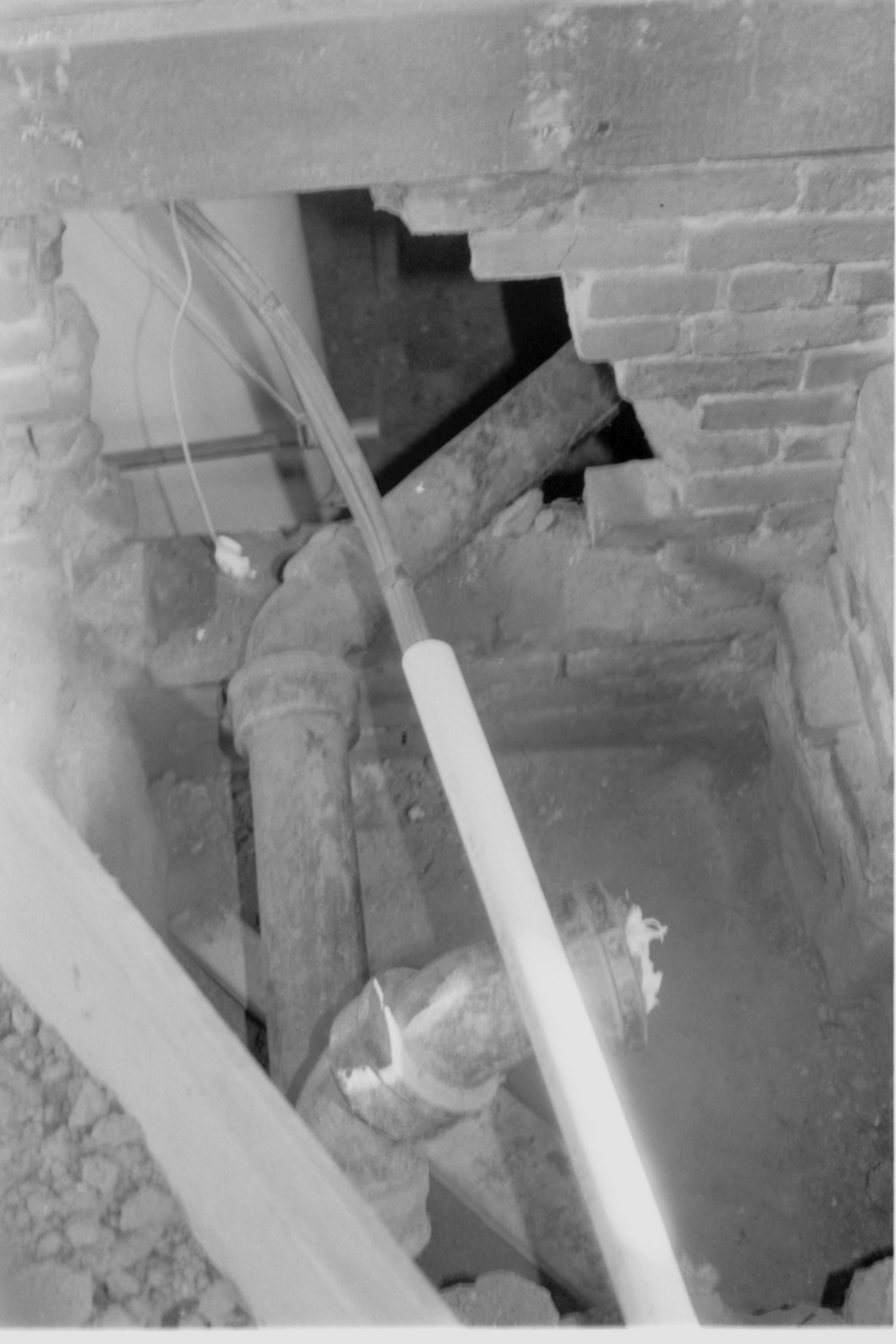 Morse House HS-9 Test Site #3. Pipes and electrical conduit leading into the Morse basement, through foundation wall. Steps can be seen to right.