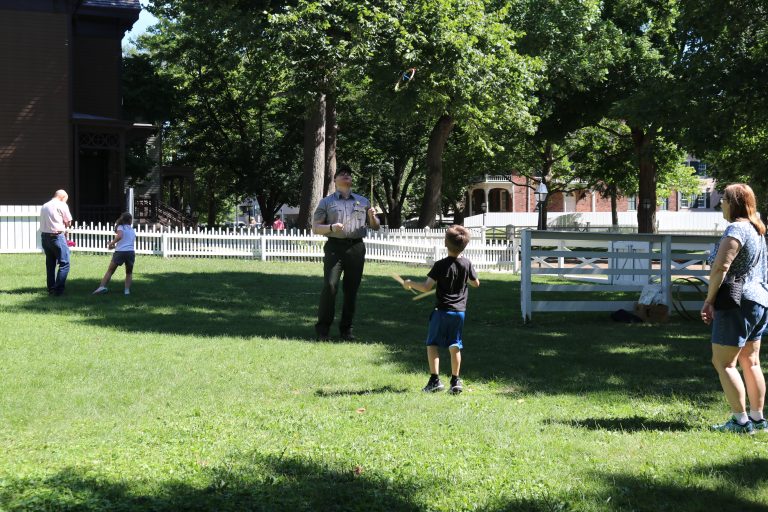 Park Guide, Max Farley, demonstrates the toy of Graces for some young visitors.